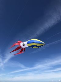 Low angle view of kite flying against blue sky