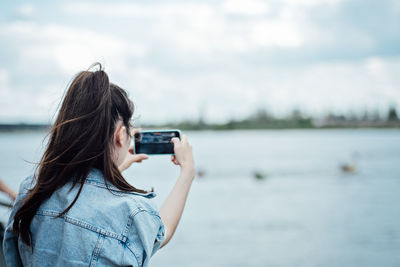 Young girl shooting photo or video on her mobile phone. girl using her cell photo to catch the