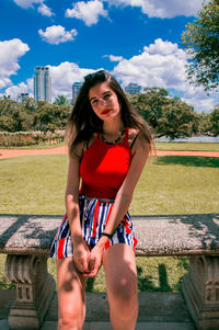 Portrait of smiling young woman against sky