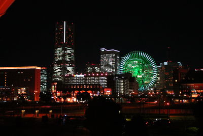 Illuminated buildings in city against sky at night