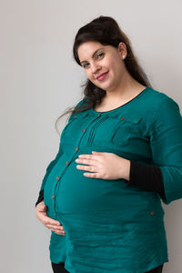 Portrait of a smiling young woman against white background