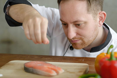 Close-up of man sprinkling spice on fish