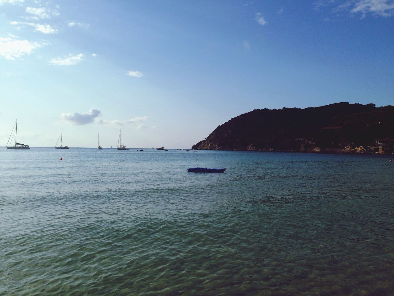 water, nautical vessel, sea, transportation, sky, boat, mode of transport, waterfront, tranquil scene, mountain, scenics, tranquility, blue, beauty in nature, nature, rippled, moored, cloud - sky, cloud, outdoors