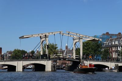 View of bridge over river against blue sky