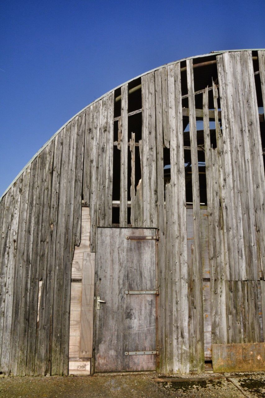 architecture, built structure, building exterior, clear sky, low angle view, blue, old, window, house, abandoned, weathered, damaged, day, building, outdoors, wall - building feature, run-down, obsolete, sunlight, exterior