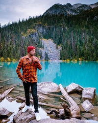 Man standing by lake against mountain