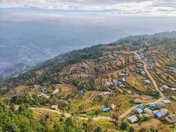 High angle view of townscape by mountain against sky