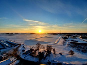 Scenic view of snow covered landscape against sky during sunset