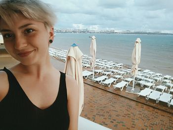 Portrait of woman by sea against sky