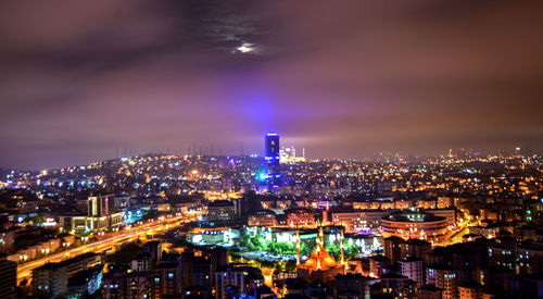 High angle view of illuminated buildings against sky at night