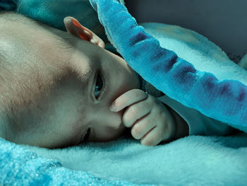 Close-up portrait of baby lying on bed