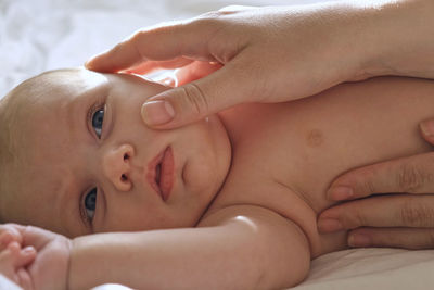 Mother giving massage to little child infant.  female hands massaging to newborn.  cream, body care