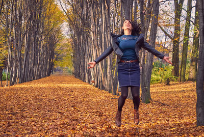 Full length of woman standing in forest