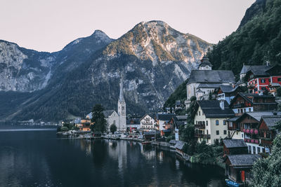 Scenic view of town by buildings and mountains against sky