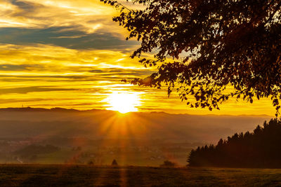 Scenic view of silhouette landscape against orange sky