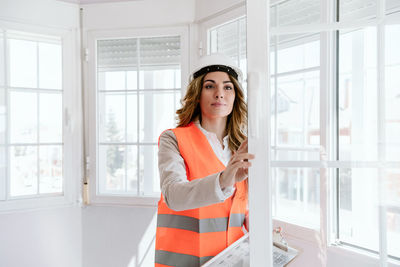 Inspector or architect professional woman checking windows at construction site. home improvement