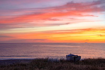 Scenic view of sea against romantic sky at sunset