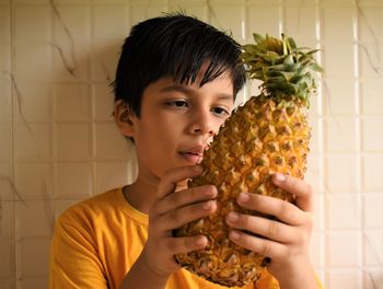 Portrait of boy holding pineapple