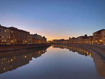 Reflection of buildings in city at sunset