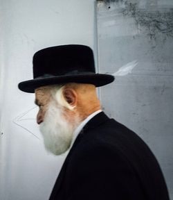 Portrait of man wearing hat against wall