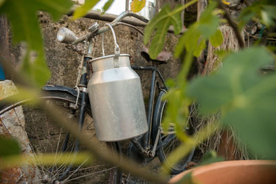 Close-up of container by plants on field