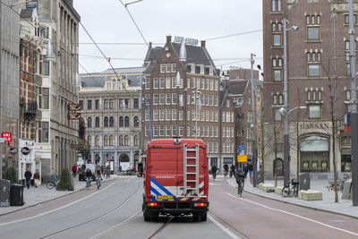 Vehicles on road by buildings in city