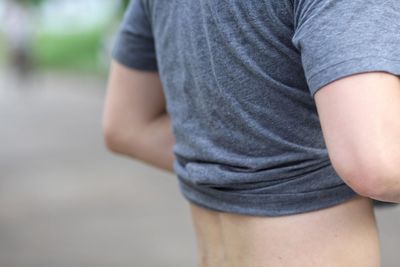 Midsection of man removing t-shirt