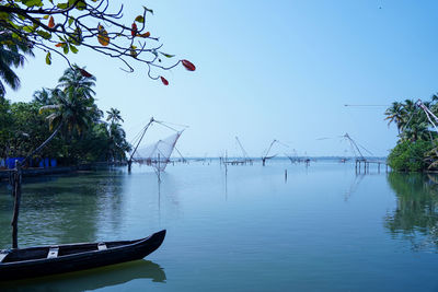 Sailboats moored on river against sky