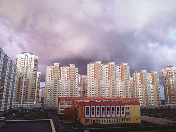 Modern buildings in city against storm clouds