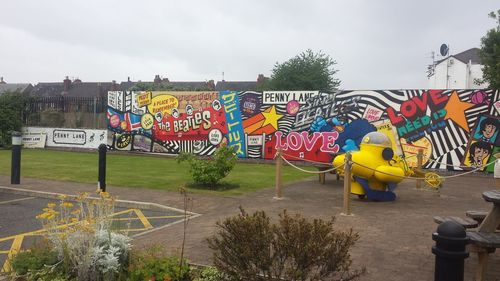 Graffiti on wall against sky in city