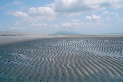 Surface level of sandy beach against sky