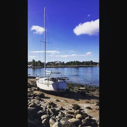 Boats in sea against cloudy sky