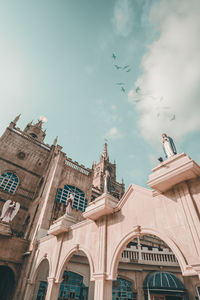 A photograph of a church building and flying birds