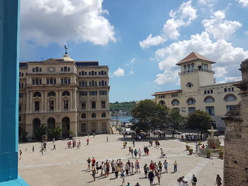 Crowded old havana streets, courtyard, and white stone buildings on a sunny day in cuba.