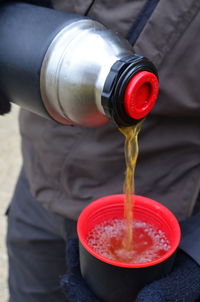 Midsection of man pouring wine in glass