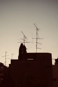 Low angle view of silhouette house against sky during sunset