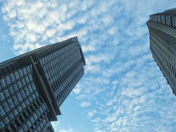 Low angle view of modern building against cloudy sky