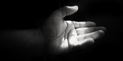 Close-up of human hand against black background