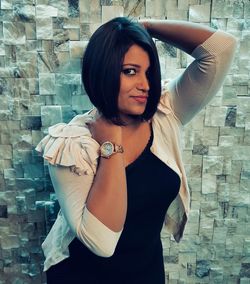 Portrait of woman standing against wall