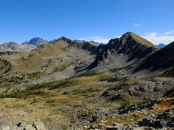 Scenic view of landscape and mountains against blue sky