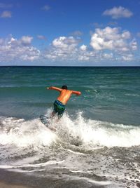 Rear view of man on beach against sky