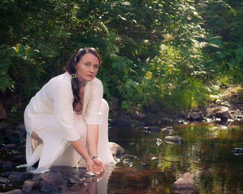 Portrait of mature woman with hands cupped in pond