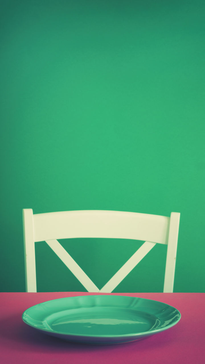 CLOSE-UP OF EMPTY CHAIRS AGAINST BLUE BACKGROUND