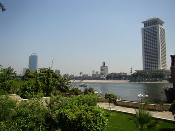 Scenic view of river and buildings against clear sky