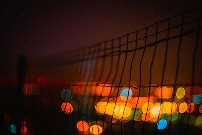 Illuminated lights against sky at night