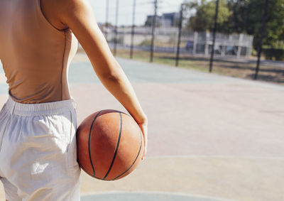 Midsection of man playing basketball