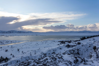 Scenic view of snow covered land against sky