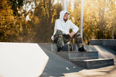 Full length of man sitting on steps in park