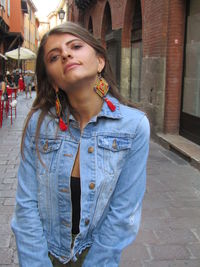 Portrait of young woman looking away in city