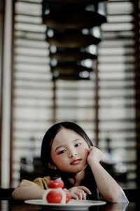 Portrait of girl sitting on table